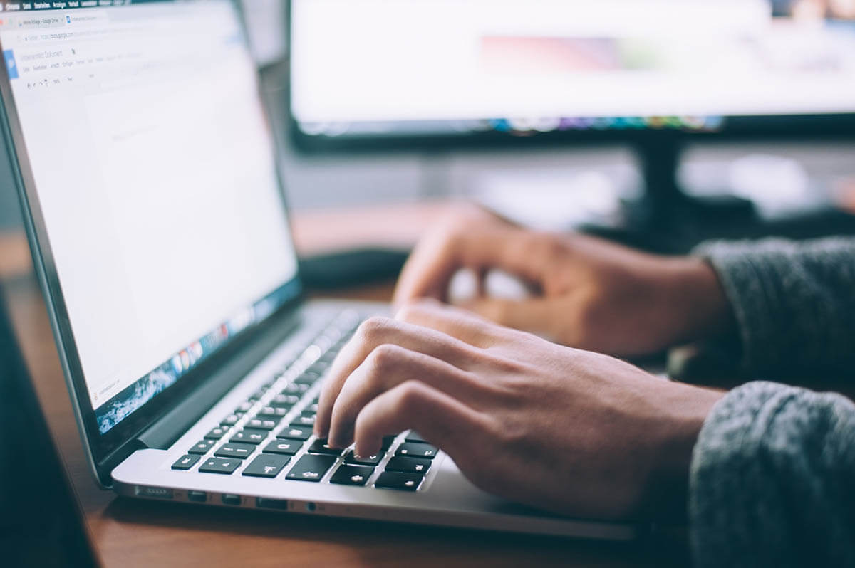 side view of hands on a laptop keyboard