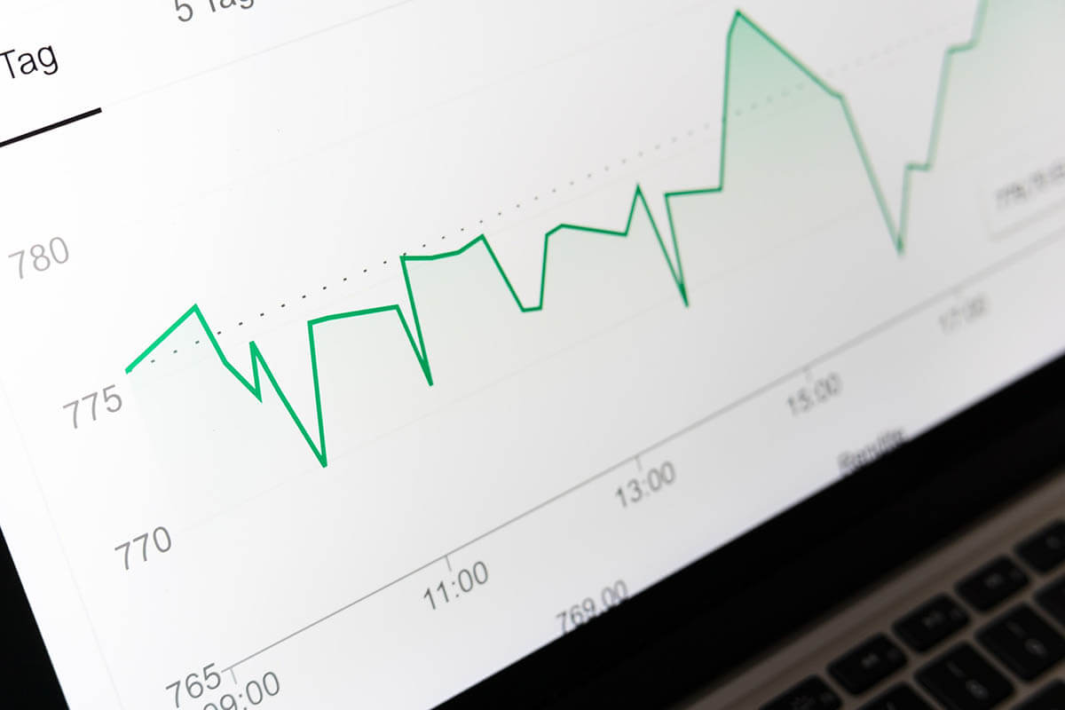 Image of a lined graph with ups and downs on an open laptop screen