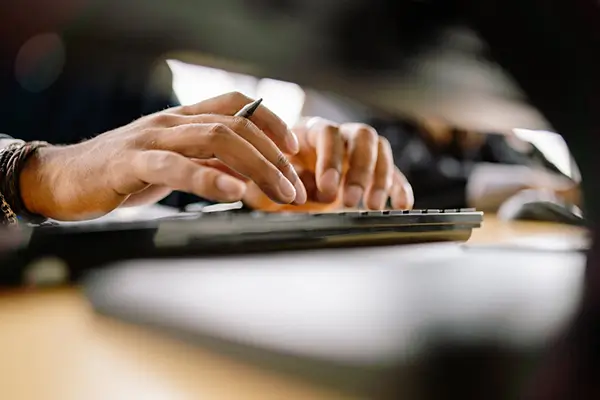 Hands typing on keyboard of a computer